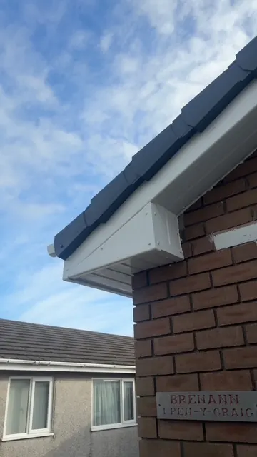 New white fascia and soffit at the corner of a brick house. One of our jobs.