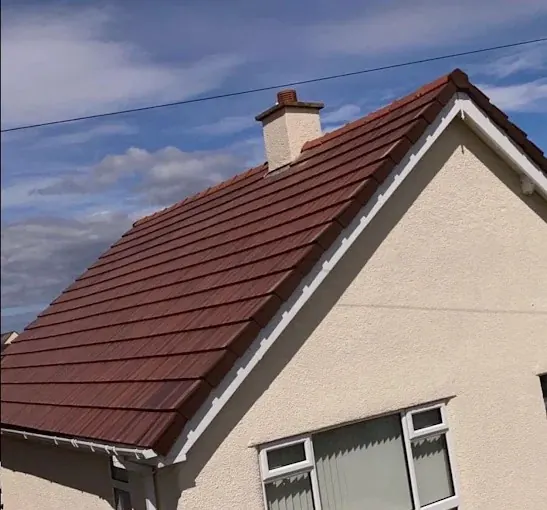 Red tiled roof with white fascias and a rendered chimney. One of our jobs.